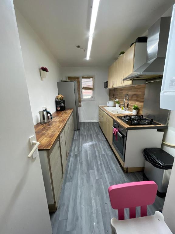 - une cuisine avec parquet et appareils en acier inoxydable dans l'établissement Appart confort T3, à Ivry-sur-Seine