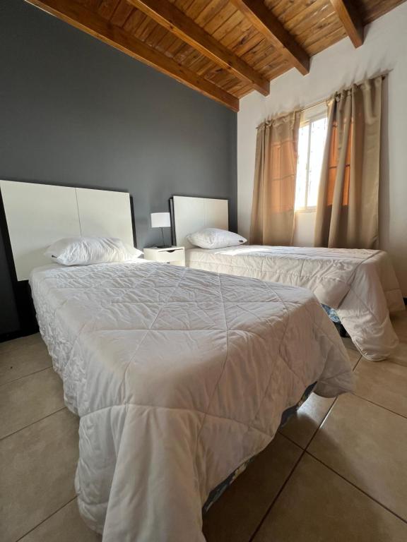 Un dormitorio con dos camas y una ventana en Portal de Dorrego, en Guaymallén