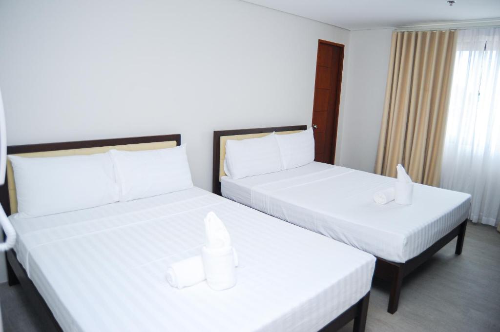 Postel nebo postele na pokoji v ubytování Kaia Isabelle Hotel Puerto Princesa