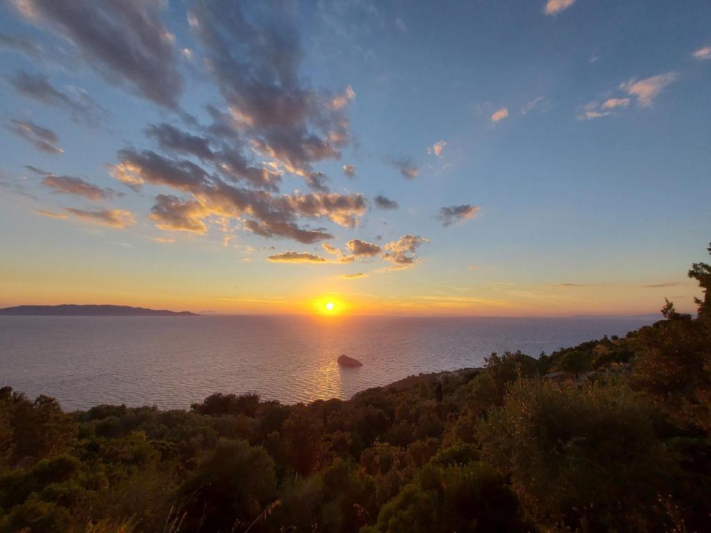 a sunset over the ocean with a boat in the water at WildSunset in Monte Argentario