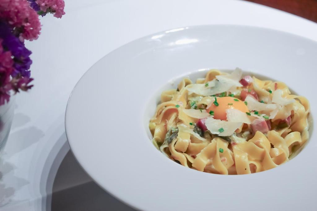 a bowl of pasta with vegetables on a white plate at Hotel Rialto in Barcelona