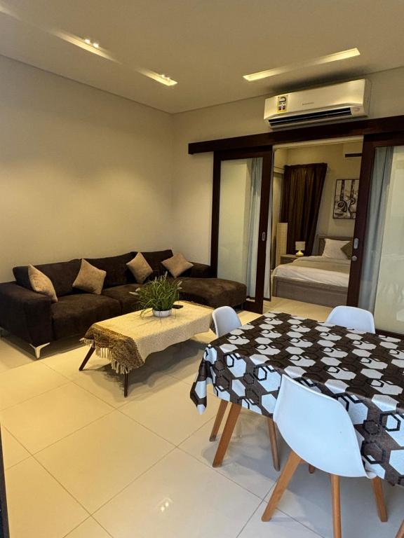 a living room with a table and a couch at Hawana Salalah Resort - Acacia 7 in Ţāqah