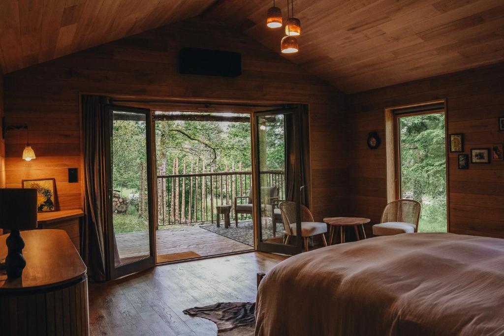 Un dormitorio con una cama y una puerta corrediza de vidrio. en BANDIAT Le Domaine, en Fargeas