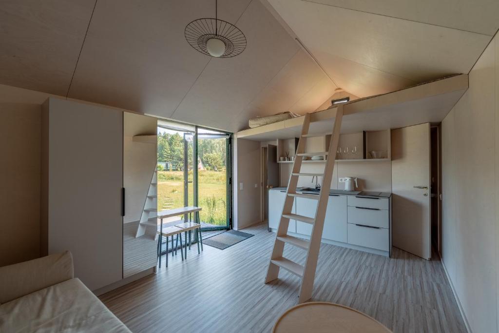 a small room with a loft bed and a kitchen at ORE guest houses in Svenele