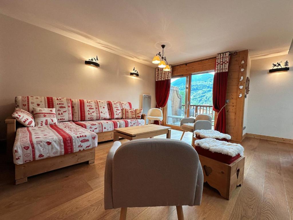 une chambre avec deux lits, un canapé et une table dans l'établissement Duplex spacieux avec piscine couverte, balcon et parking, à 300m du centre et proche des pistes - FR-1-624-137, à Samoëns