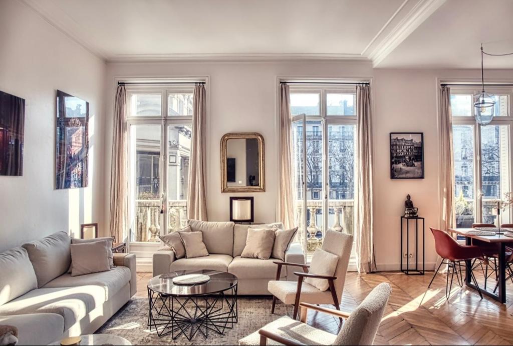 d'un salon avec des meubles blancs et des fenêtres. dans l'établissement Chic et décontracté centre de paris, à Paris