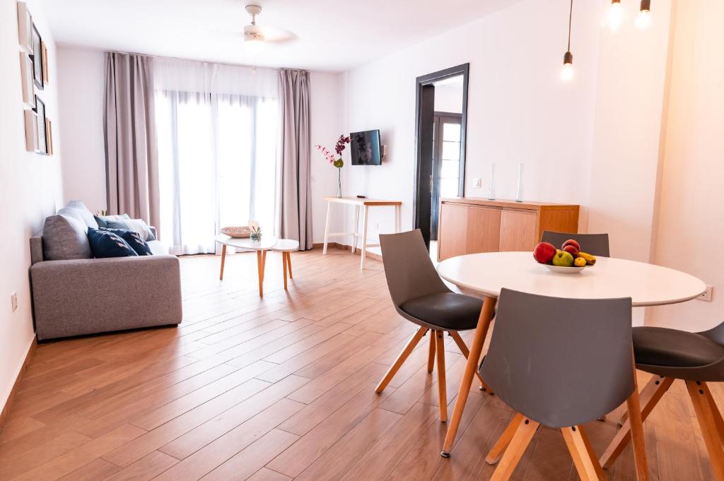 a living room with a table and chairs at Los Cardones Boutique Village in Playa de las Americas