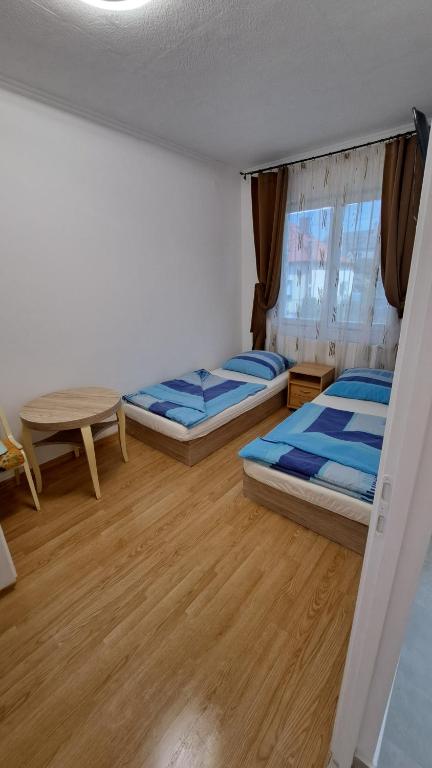 a room with two beds and a table in it at All-in-a good space in Budapest