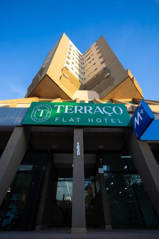 a building with a sign on the front of it at Terraço Flat Hotel in Dourados