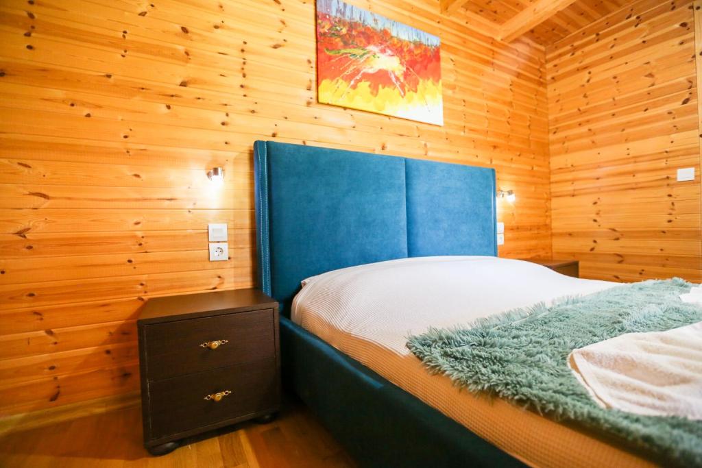 ein Schlafzimmer mit einem Bett in einer Holzhütte in der Unterkunft Holiwood in Himarë