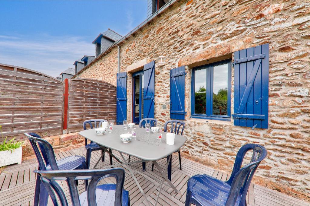- une table et des chaises sur une terrasse avec un bâtiment dans l'établissement Jolie maison pour 5 sur la presqu ile de Rhuys, à Le Tour-du-Parc