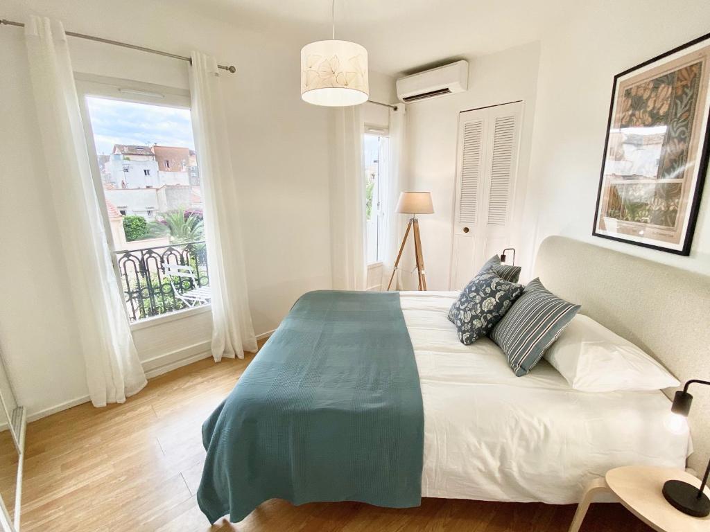 une chambre avec un grand lit et une grande fenêtre dans l'établissement Le Guillaumont - Amazing 2-bedroom in the Old Town -StayInAntibes, à Antibes