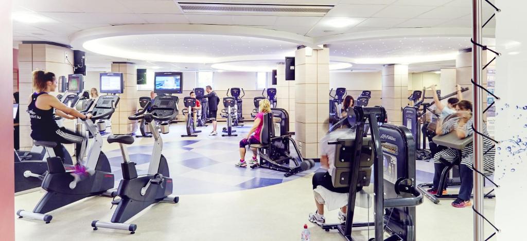 a gym with people exercising on tread machines at Mondorf Parc Hotel & Spa in Mondorf-les-Bains