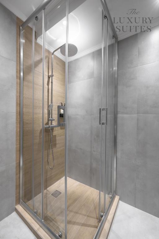 W łazience znajduje się prysznic ze szklanymi drzwiami. w obiekcie Aelia Apartments, The Luxury Suites w Salonikach