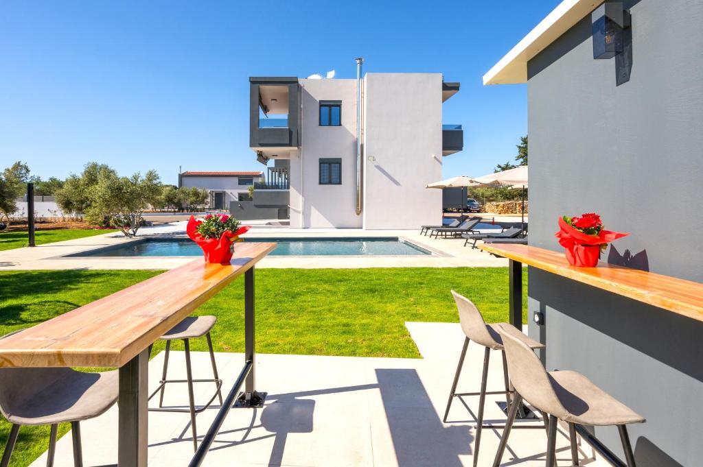 a patio with a table and chairs and a swimming pool at Luxury Oasis in Chania - Private Pool, BBQ & Garden by WeHome in Chania Town