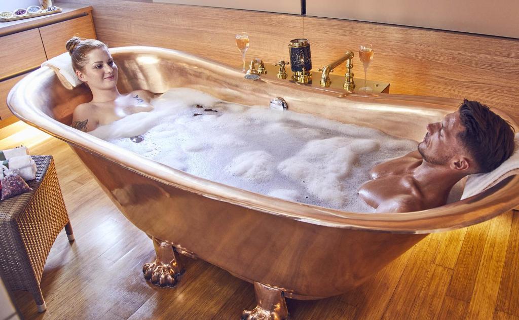 a man and a woman in a bath tub at Mondorf Parc Hotel & Spa in Mondorf-les-Bains