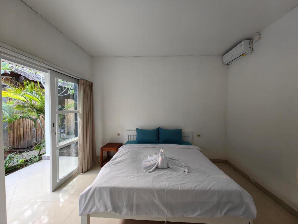 una camera da letto con un letto e una grande finestra di Aalayam homestay a Nusa Lembongan