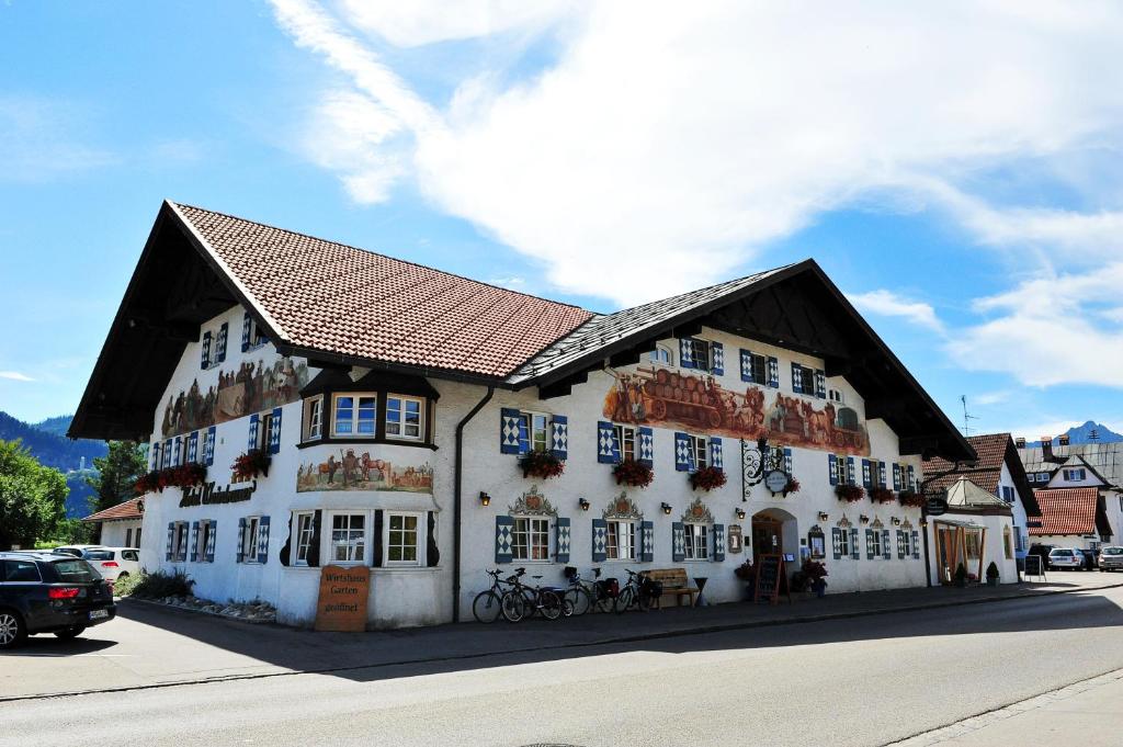 a large white building with a brown roof at Hotel Weinbauer in Schwangau