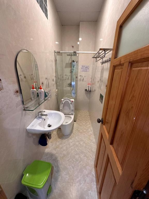 un bagno con lavandino, water e specchio di Gia Hạ House View Đồi Thông-Pine hill-R21 a Da Lat