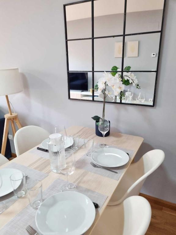 a dining room table with white plates and a mirror at EL RINCÓN DE SAN NICOLÁS in Soria