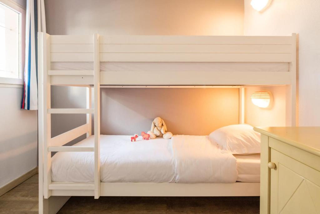a white bunk bed with a teddy bear sitting on it at Résidence Pierre & Vacances l'Ange Gardien in Villefranche-sur-Mer