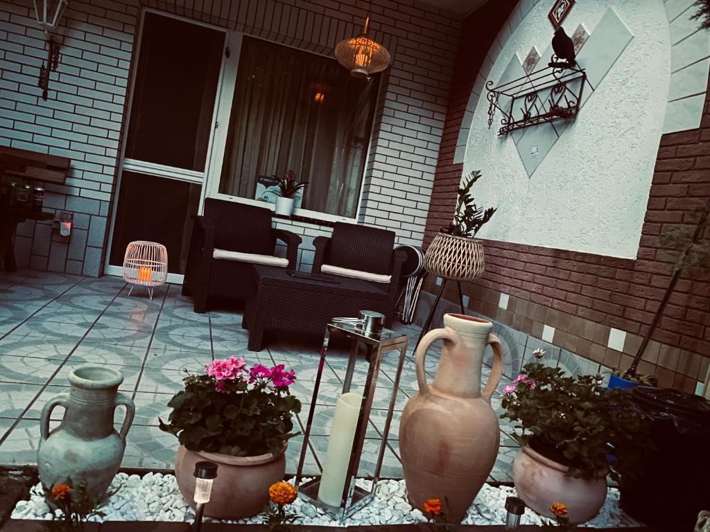 a patio with vases and plants on a house at Silver Lake Apartman in Balatonboglár