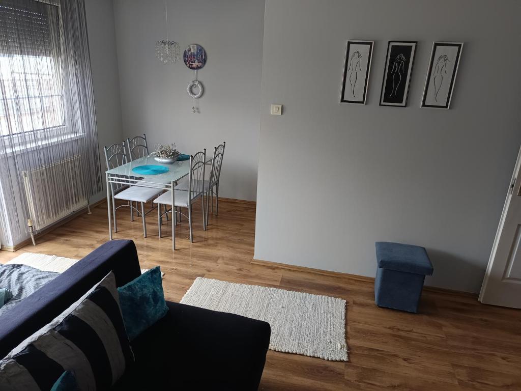 a living room with a couch and a table and chairs at Lia Apartman in Nyíregyháza