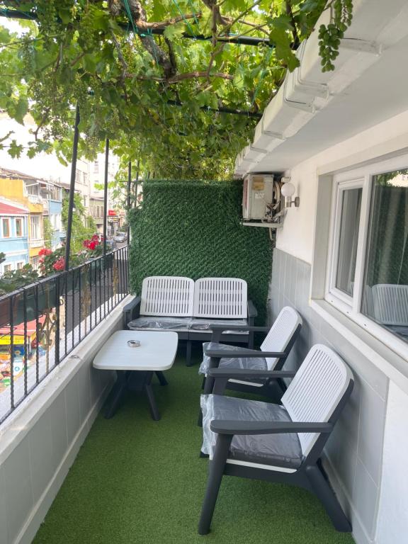 three chairs and a table on a balcony at Taksim Neo Pera Suites in Istanbul