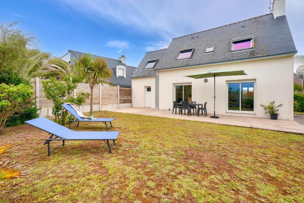une maison avec un banc bleu dans la cour dans l'établissement Maison pour 4 adultes, 1 enfant à 200m de la plage, au Guilvinec