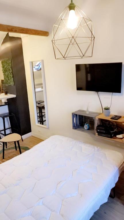 une chambre avec un lit blanc et une télévision à écran plat dans l'établissement Studio cosy Nice centre quartier Musiciens, à Nice