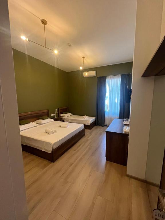 a large room with two beds and a bathroom at Hotel Tabernei in Tbilisi City