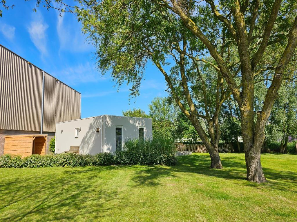 een huis in een veld met een boom bij Vakantiewoning Studio 51 OK49 in Oostkapelle