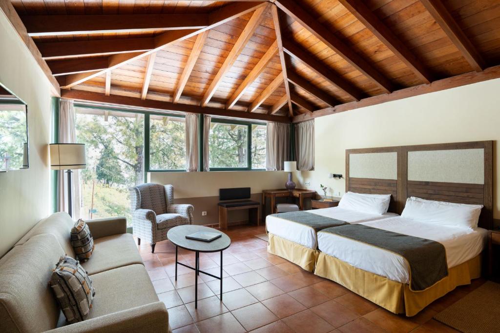 un dormitorio con una cama y un sofá en Parador de Cruz de Tejeda, en Tejeda