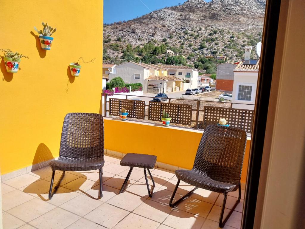 a balcony with two chairs and a yellow wall at Costa Blanca Villa With Private Pool and Aircon in Benimeli
