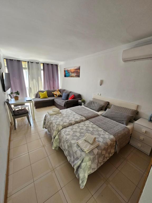 een slaapkamer met een groot bed en een bank bij Apartamento Florido in Torremolinos