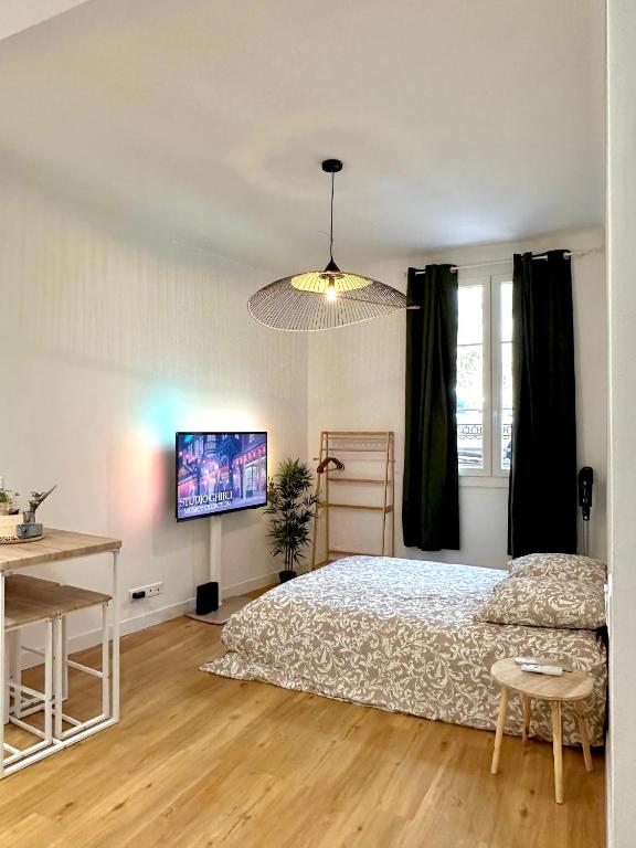 une chambre avec un lit, un bureau et une télévision dans l'établissement Studio Cosy à Nice Centre, à Nice