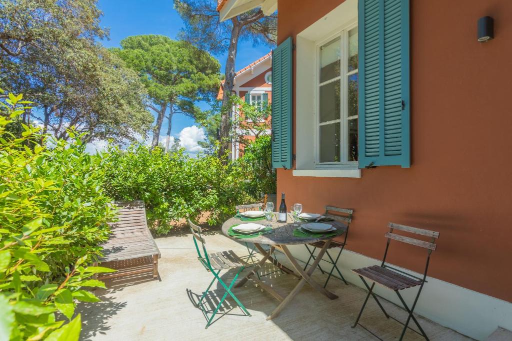 a patio with a table and chairs and a window at Chalet au bord de l'eau in Fréjus