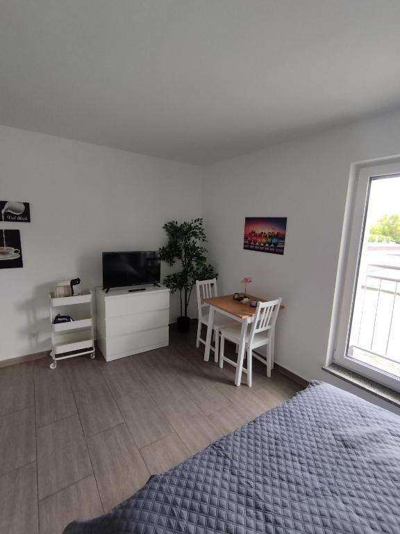 sypialnia z łóżkiem, stołem i telewizorem w obiekcie Concept Köln w Kolonii