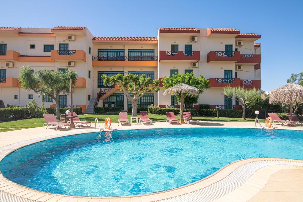 a large swimming pool in front of a building at Portokali Apartments in Hersonissos