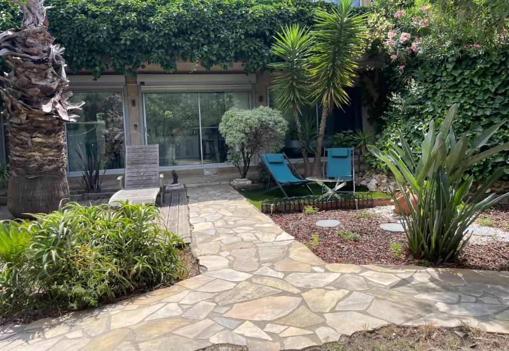 un patio avec des chaises et des plantes devant un bâtiment dans l'établissement Emeraude 2.0, à Rayol-Canadel-sur-Mer