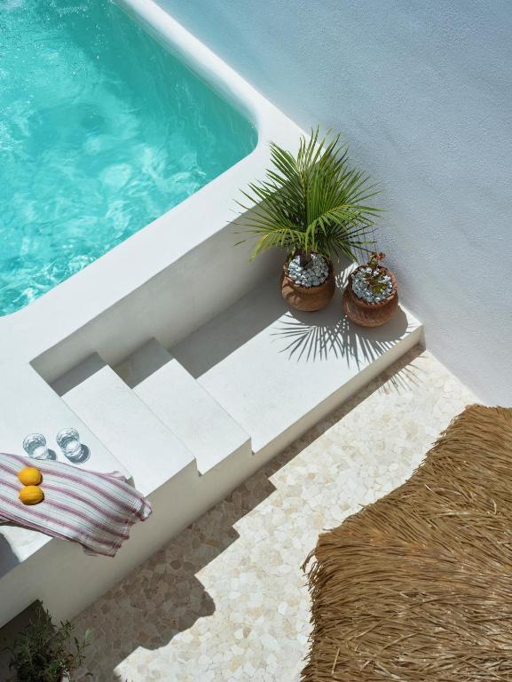 a swimming pool with two potted plants next to a swimming pool at Casa nueva con piscina privada y solárium in Alcalá de Guadaira