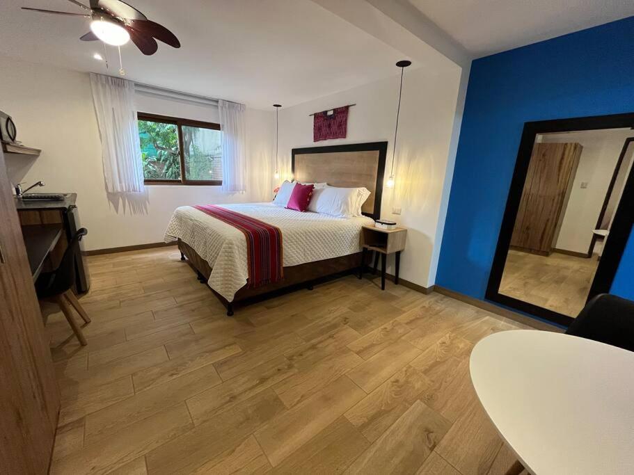 une chambre avec un lit, une table et un miroir dans l'établissement Dk4-Studio for 4 in Zona Viva, à Guatemala