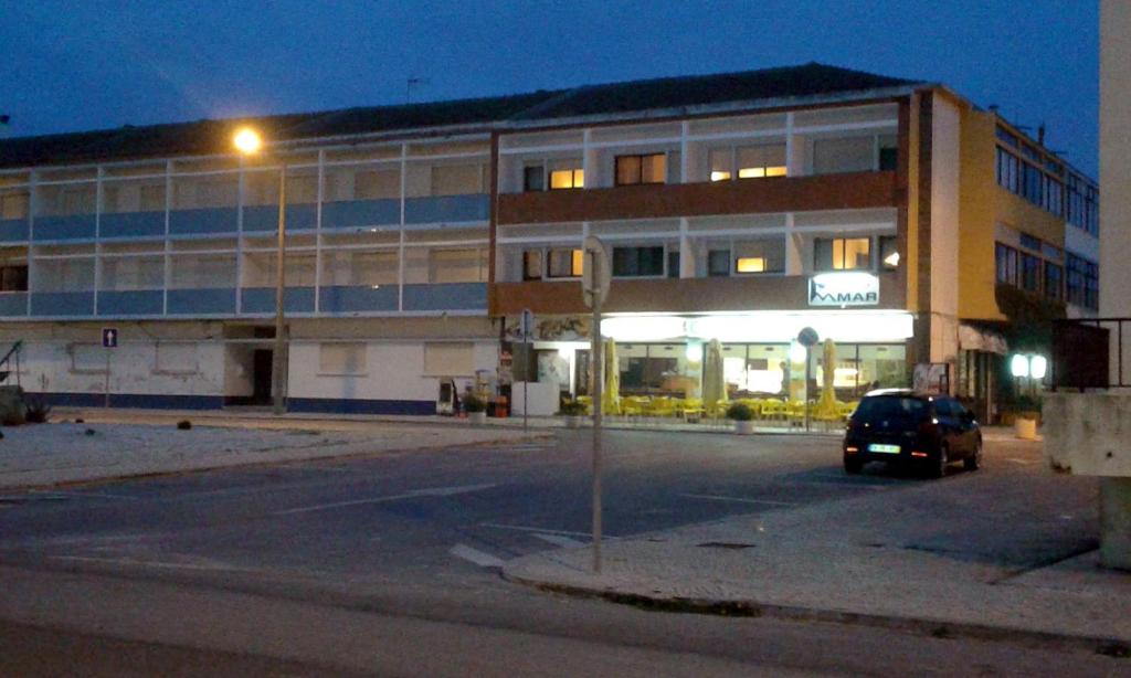 un'auto parcheggiata di fronte a un edificio di notte di Residencial do Mar a Praia de Mira