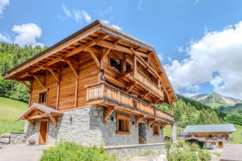 Cette grande cabane en rondins est dotée d'un toit en bois. dans l'établissement CHALET LES EVES, à Morzine