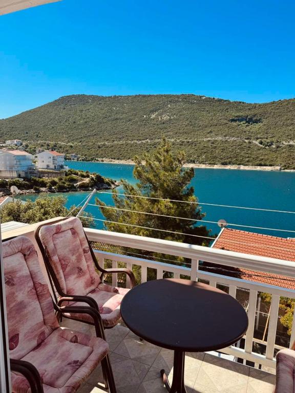 a balcony with two chairs and a table and water at SEA Apartments in Neum