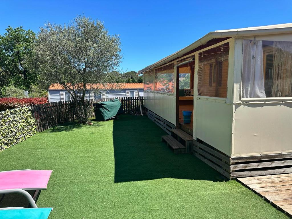 une grande serre avec une cour avec de l'herbe dans l'établissement Camping les Cigales - Tikayan, au Muy