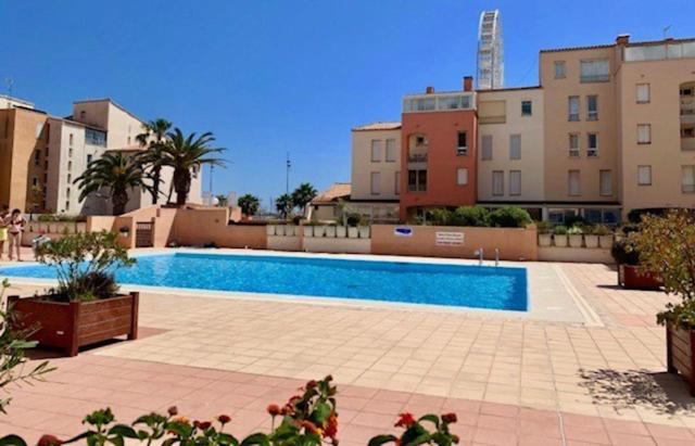 une grande piscine dans une ville avec des immeubles dans l'établissement T5 cap d'agde centre port & piscine, au Cap d'Agde