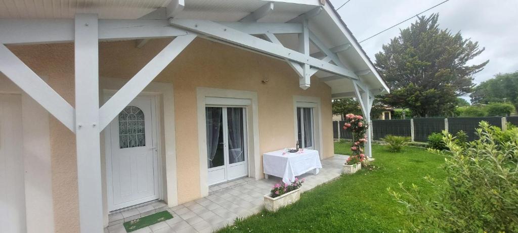 - une terrasse couverte à l'avant d'une maison avec une porte blanche dans l'établissement Maison Solyne Andernos les Bains, à Andernos-les-Bains
