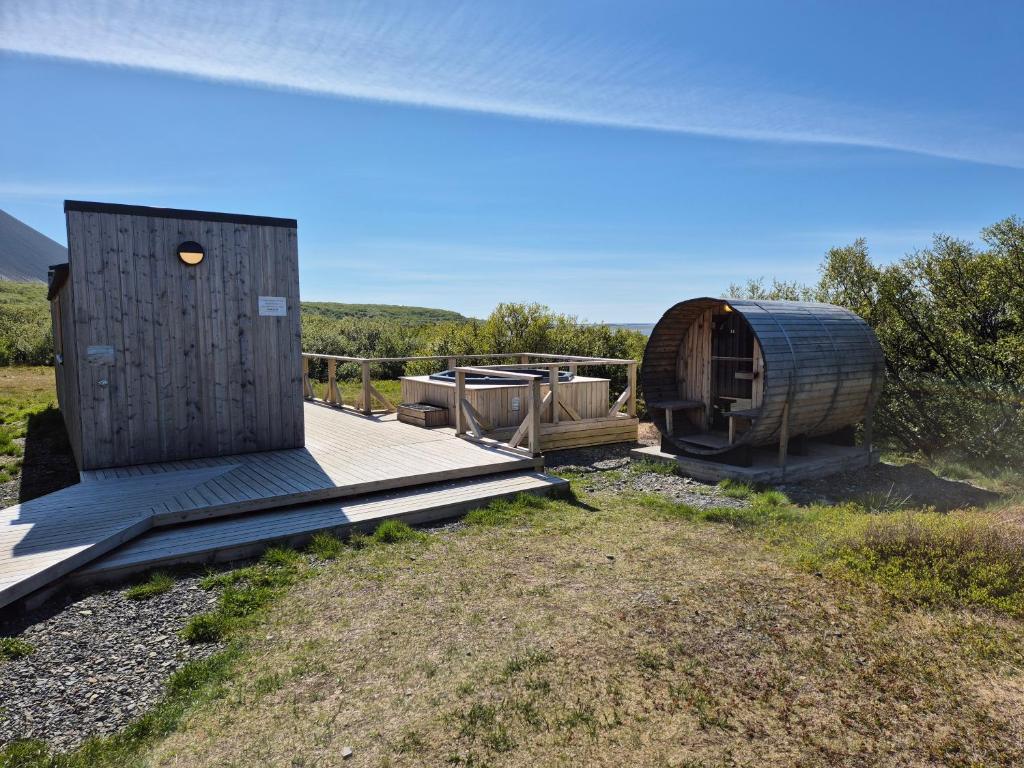 a wooden deck with a hobbit house in a field at Hotel Hafnarfjall in Borgarnes