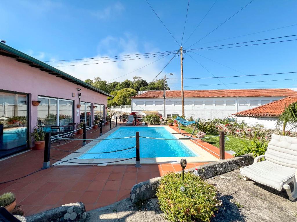 a swimming pool in front of a house at Sossego da Laurinda in Vila Praia de Âncora